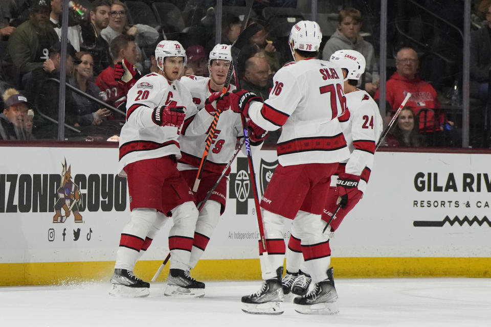 Carolina Hurricanes center Sebastian Aho (20) celebrates with right wing Andrei Svechnikov (37), center Seth Jarvis (24), and defenseman Brady Skjei after scoring against the Arizona Coyotes in the first period during an NHL hockey game, Friday, March 3, 2023, in Tempe, Ariz. (AP Photo/Rick Scuteri)