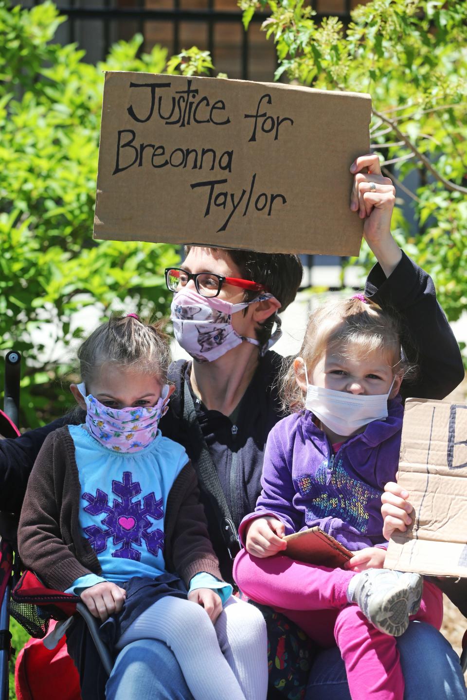 Anne Schmidt of Milwaukee is joined by her twin daughters, Anya, left, and Naomi, 4, at the  "Sit-in for Change" protest on Saturday.