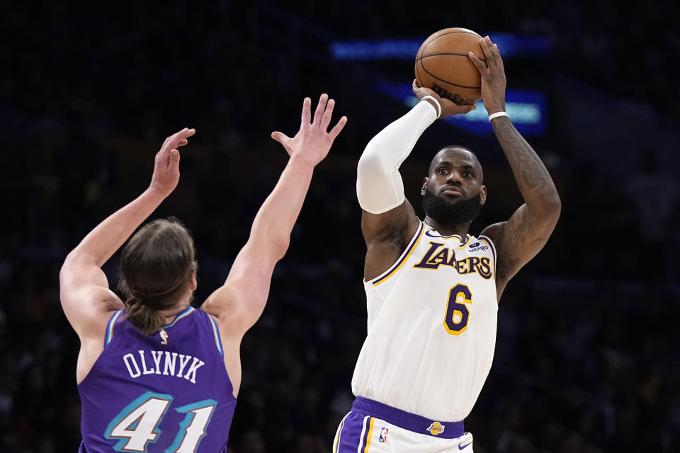 Los Angeles Lakers forward LeBron James, right, shoots as Utah Jazz forward Kelly Olynyk defends during the first half of an NBA basketball game Sunday, April 9, 2023, in Los Angeles. (AP Photo/Mark J. Terrill)