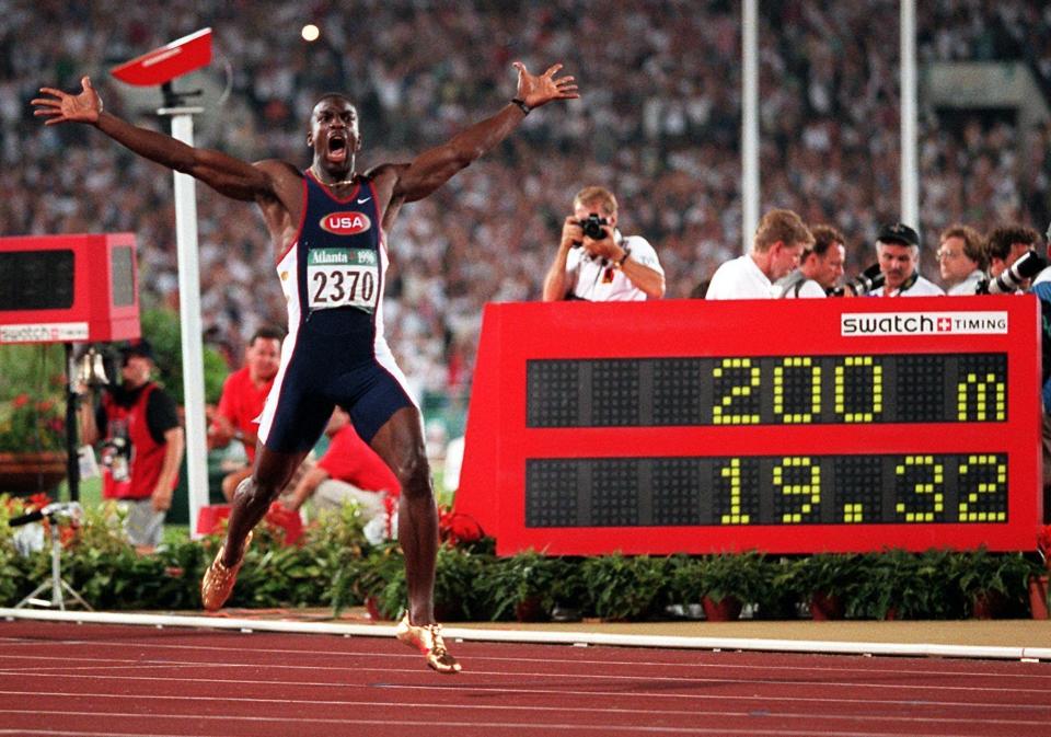 FILE - In this Aug. 1, 1996, file photo, Michael Johnson, of the United States, celebrates after he won the men's 200 meter final in a world record time of 19.32 at the 1996 Summer Olympic Games in Atlanta. (AP Photo/Doug Mills, File)