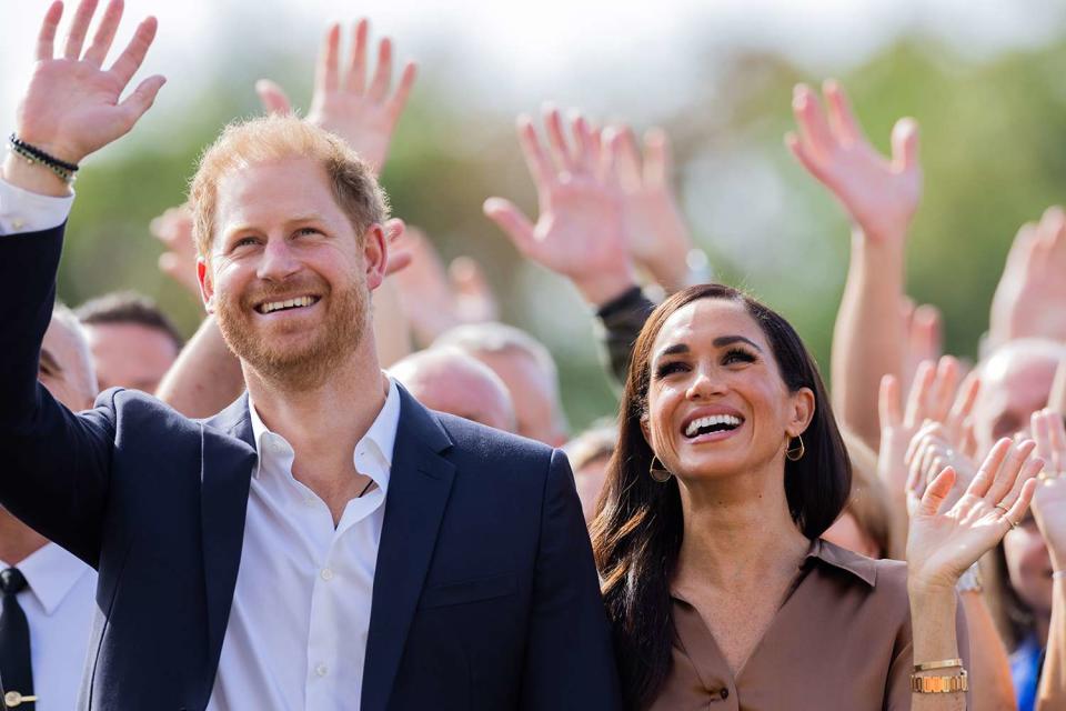 <p>Rolf Vennenbernd/picture alliance via Getty Images</p> Prince Harry and Meghan Markle cheer at the 2023 Invictus Games