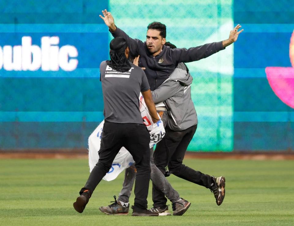 A protestor is stopped by stadium security after rushing the field during the game between the United States and Cuba at the World Baseball Classic semifinal at loanDepot Park in Miami, Fla. on Sunday, March 19, 2023.