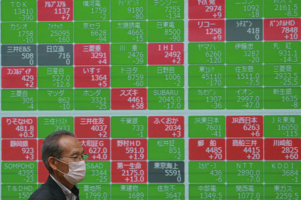 A man walks by an electronic stock board of a securities firm in Tokyo, Wednesday, May 19, 2021. Asian shares fell Wednesday, tracking a decline on Wall Street led by big technology stocks. (AP Photo/Koji Sasahara)