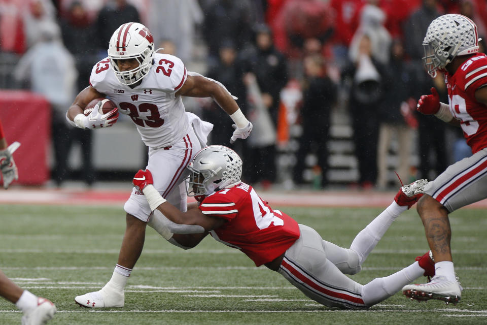 Wisconsin running back Jonathan Taylor, left, tries to cut up field past Ohio State linebacker Justin Hilliard during the first half of an NCAA college football game Saturday, Oct. 26, 2019, in Columbus, Ohio. (AP Photo/Jay LaPrete)