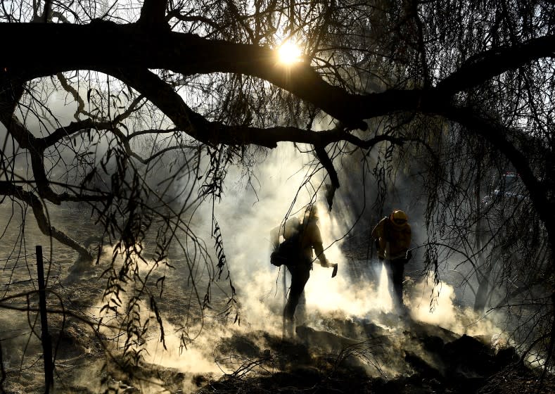 SILVERADO, CALIFORNIA DECEMBER 2, 2020-Firefighters estinguish hot spots from the Bond Fire along Santiago Canyon Road in the Silverado area Thursday. (Wally Skalij/Los Angeles Times)