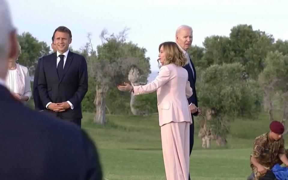 Giorgia Meloni guides Joe Biden back towards the group