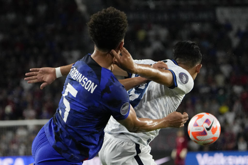 United States defender Antonee Robinson (5) gets tangled up with El Salvador forward Kevin Reyes, right, going for the ball during the first half of a CONCACAF Nations League soccer match Monday, March 27, 2023, in Orlando, Fla. (AP Photo/John Raoux)