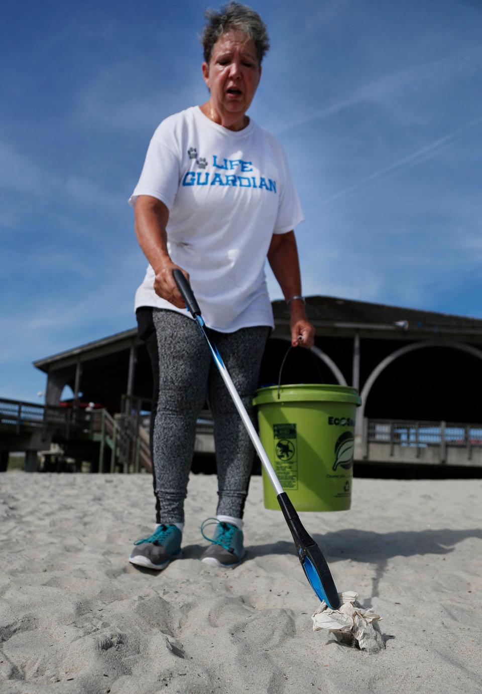Volunteer Marie Posey-Rodriguez picks up trash off the beach near the Tybee Island Pier.