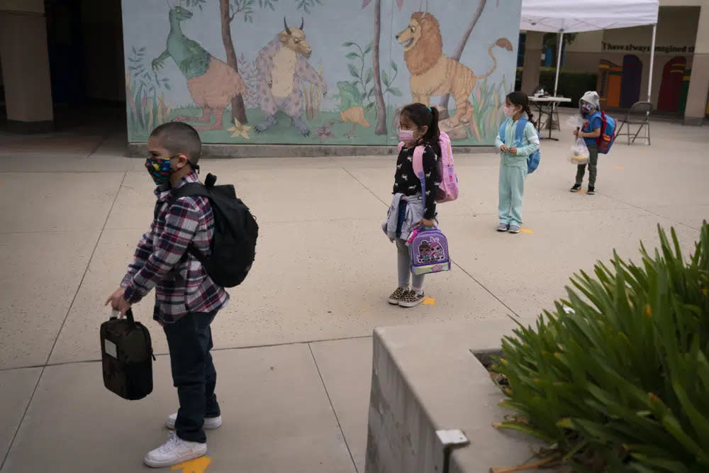 Socially distanced kindergarten students wait for their parents to pick them up on the first day of in-person learning at Maurice Sendak Elementary School on April 13, 2021, in Los Angeles. (AP Photo/Jae C. Hong, File)