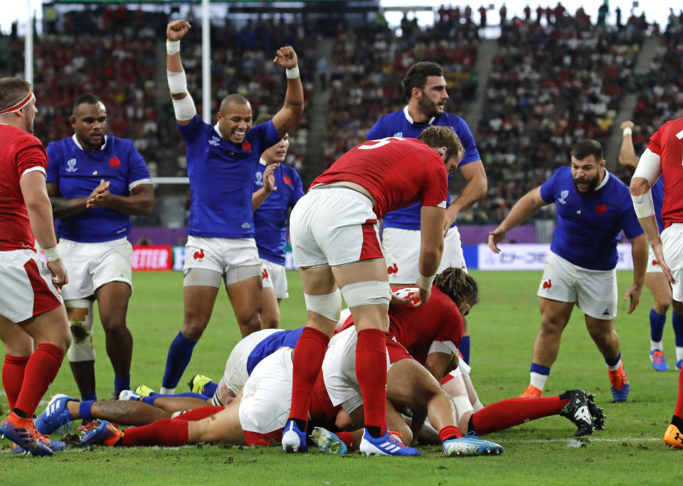 France's Sebastien Vahaamahina, at bottom, scores a try during the Rugby World Cup quarterfinal match against Wales at Oita Stadium in Oita, Japan, Sunday, Oct. 20, 2019. (AP Photo/Christophe Ena)