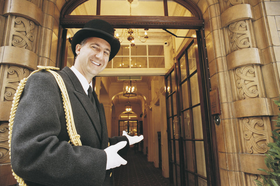 Doorman Gesturing Towards a Hotel Entrance