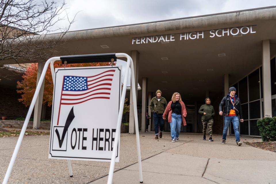 People walk by a sign for voting at Ferndale High School in Ferndale on Tuesday, November 7, 2023.