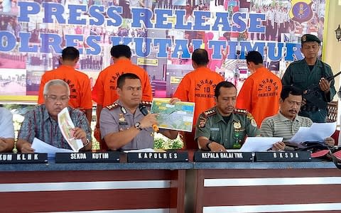 The Kutai Timur police hold a press conference to display to the media four men accused of the killing an orangutan