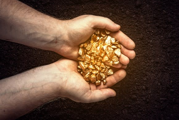 A man cupping chunks of gold in his hands.