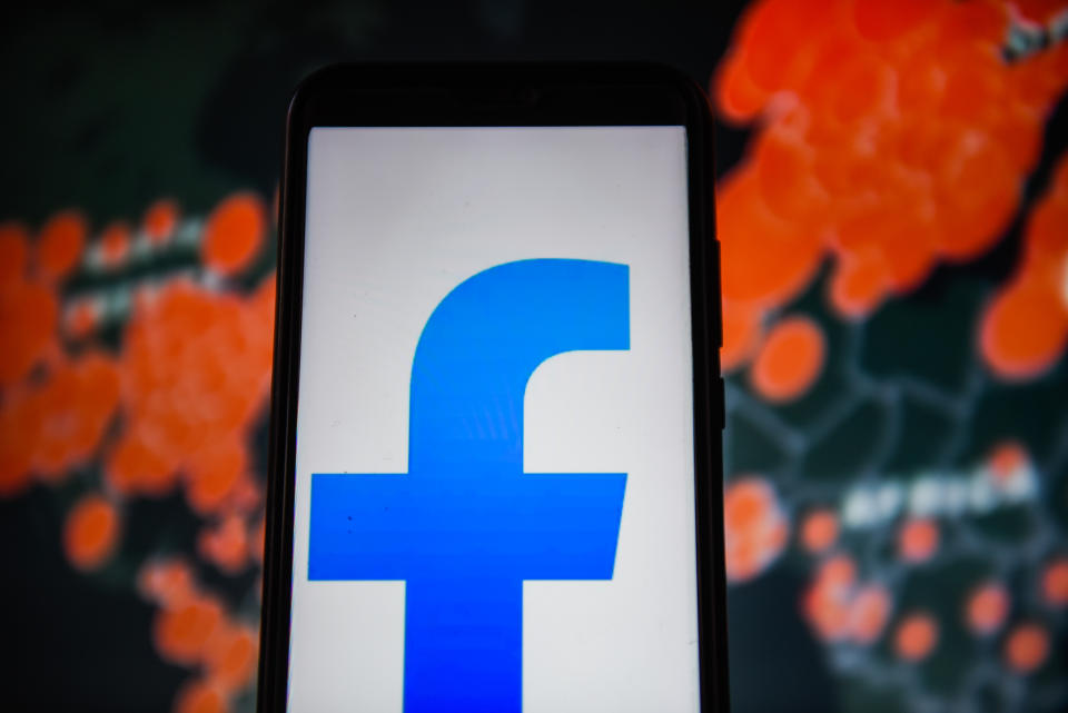 POLAND - 2020/04/01: In this photo illustration a Facebook Lite logo is seen displayed on a smartphone with a World map of COVID 19 epidemic on the background. (Photo Illustration by Omar Marques/SOPA Images/LightRocket via Getty Images)