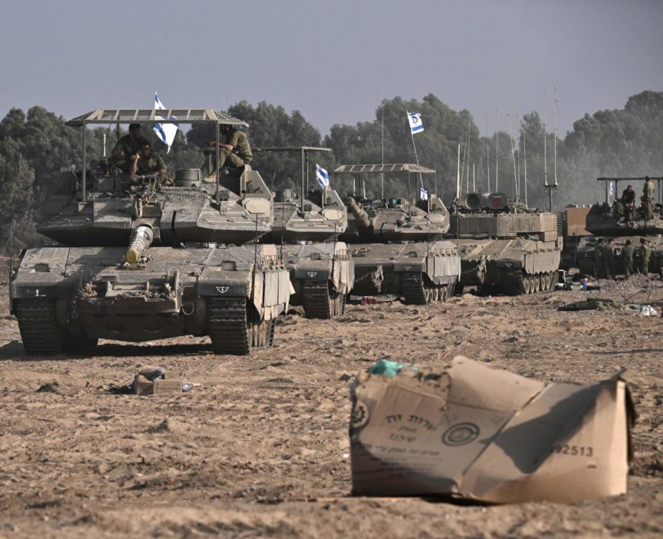 Israeli Merkava Mk 4 tanks seem in October 2023 with an earlier type of armor screen on top of their turrets. <em>ARIS MESSINIS/AFP via Getty Images</em>