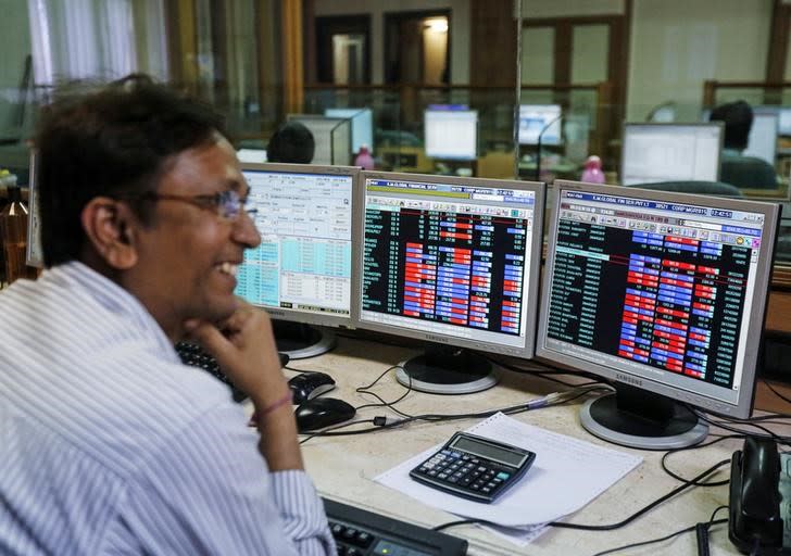 A broker laughs while speaking to a colleague, as they trade on their computer terminals at a stock brokerage firm in Mumbai, March 4, 2015. REUTERS/Shailesh Andrade/Files