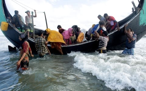 Rohingya Refugees disembark from a boat at the shore of Naf river - Credit: EPA