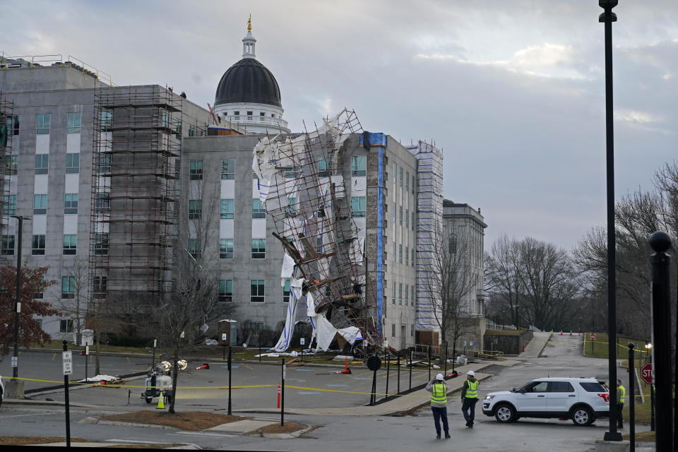 Workers view a scaffolding destroyed by Monday's high winds at the Burton M. Cross State Office building, Tuesday, Dec. 19, 2023, in Augusta, Maine. (AP Photo/Robert F. Bukaty)