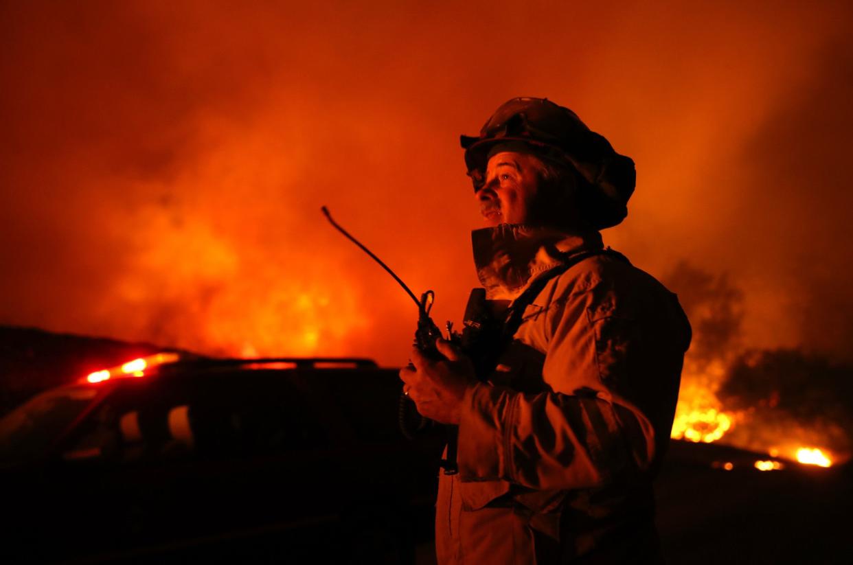 A firefighter monitors the Kincaide Fire as it burns through the area on Oct. 24, 2019 in Geyserville, Calif.