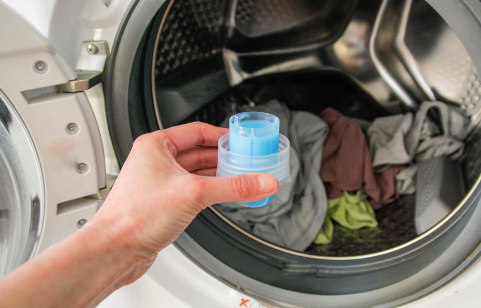 person holding cup of fabric softener