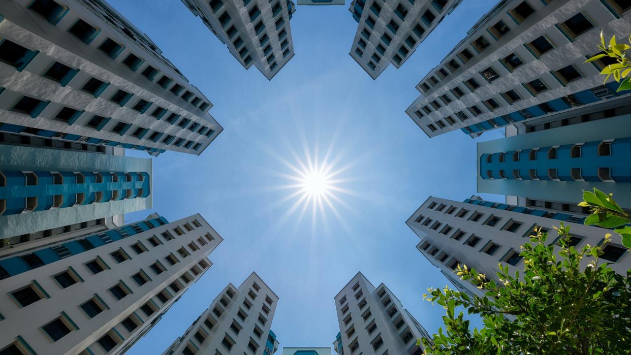  A bottom-up view of a cluster of public residential apartments facing the afternoon sun in Jurong West, Singapore. 