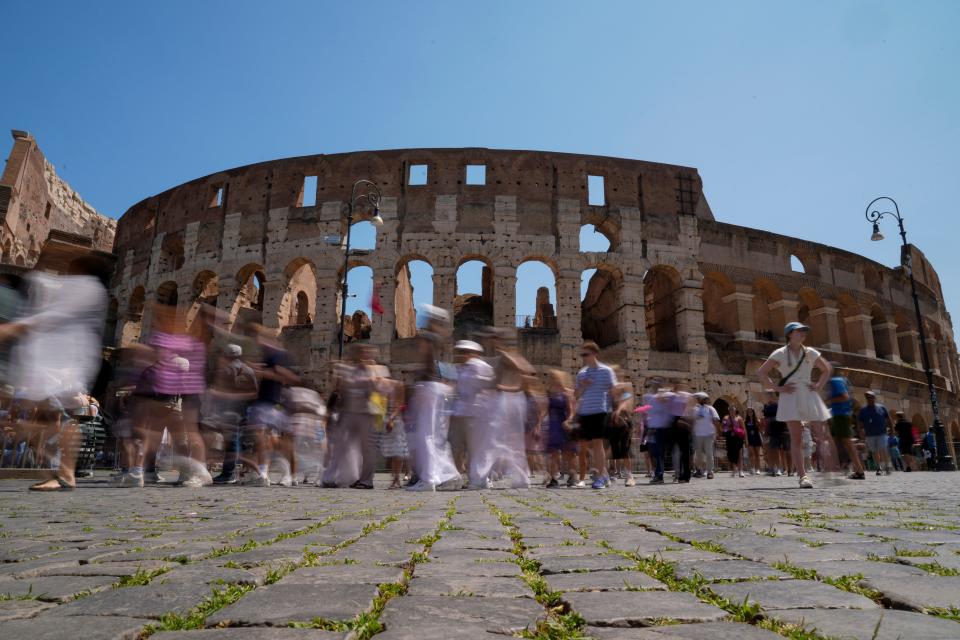 Visitors walk past the Colosseum, in Rome, Tuesday, June 27, 2023.