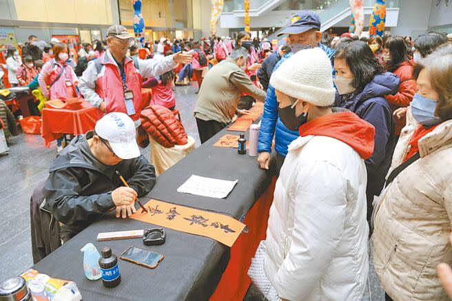 台中市政府24日邀請152位書法名家免費揮毫贈春聯，現場還能索取賀聯、紅包袋。（張亦惠攝）
