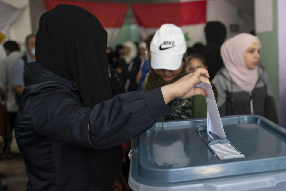 A Syrian woman votes during the Presidential elections, at a polling station in the town of Douma, near the Syrian capital Damascus, Syria, Wednesday, May 26, 2021. Syrians headed to polling stations early Wednesday to vote in the second presidential elections since the deadly conflict began in the Arab country. (AP Photo/Hassan Ammar)