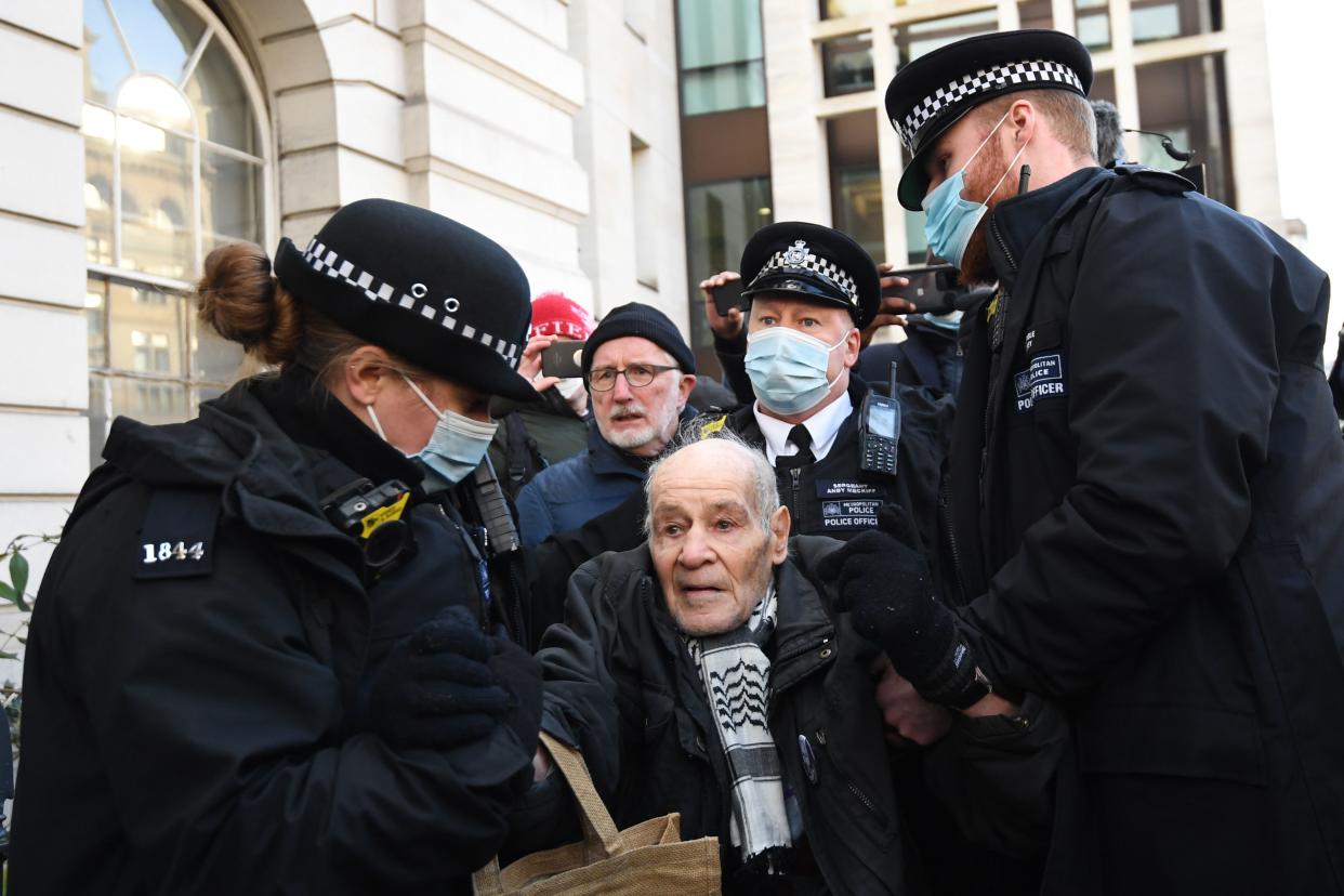 Police arrest a supporter of Wikileaks founder Julian Assange outside Westminster Magistrates court in London as he appears for a bail hearing on January 6, 2021. (Photo by DANIEL LEAL-OLIVAS / AFP) (Photo by DANIEL LEAL-OLIVAS/AFP via Getty Images)