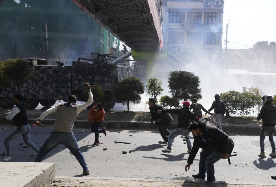 Nepalese protesters opposing a proposed U.S. half billion dollars grant for Nepal clash with police outside as the parliament debates the contentious aid in Kathmandu, Nepal, Sunday, Feb. 20, 2022. Opposition to the grant comes mainly from two Communist parties that are part of the coalition government who claim the conditions in the grant agreement will prevail over Nepal's laws and threaten the country's sovereignty. (AP Photo/Niranjan Shreshta)