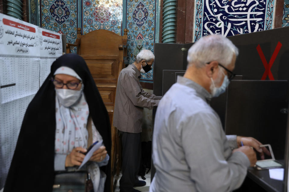 Voters fill out their ballot papers during the presidential elections at a polling station in Tehran, Iran, Friday, June 18, 2021. Iran began voting Friday in a presidential election tipped in the favor of a hard-line protege of Supreme Leader Ayatollah Ali Khamenei, fueling public apathy and sparking calls for a boycott in the Islamic Republic. (AP Photo/Vahid Salemi)