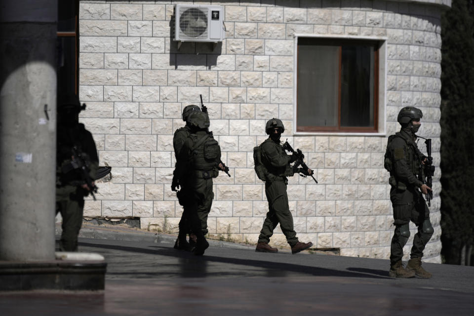 Israeli soldiers search in the West Bank village of Qafin for the suspected gunmen who shot and killed an Israeli civilian near the entrance to a Jewish settlement of Hermesh, Tuesday, May 30, 2023. (AP Photo/Majdi Mohammed)