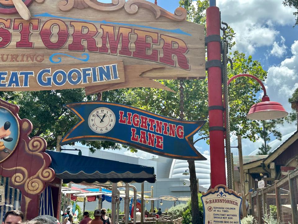 lightning lane sign in front of goofys barnstormer at magic kingdom in disney world