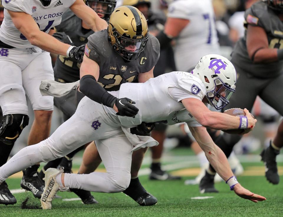 Holy Cross quarterback Matthew Sluka (9) is tackled by Army linebacker Leo Lowin (31) during the second half Saturday at Michie Stadium.