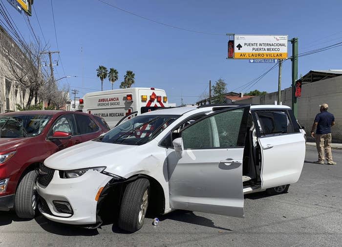 A member of the Mexican security forces stands next to a white minivan with North Carolina plates and several bullet holes on Friday.