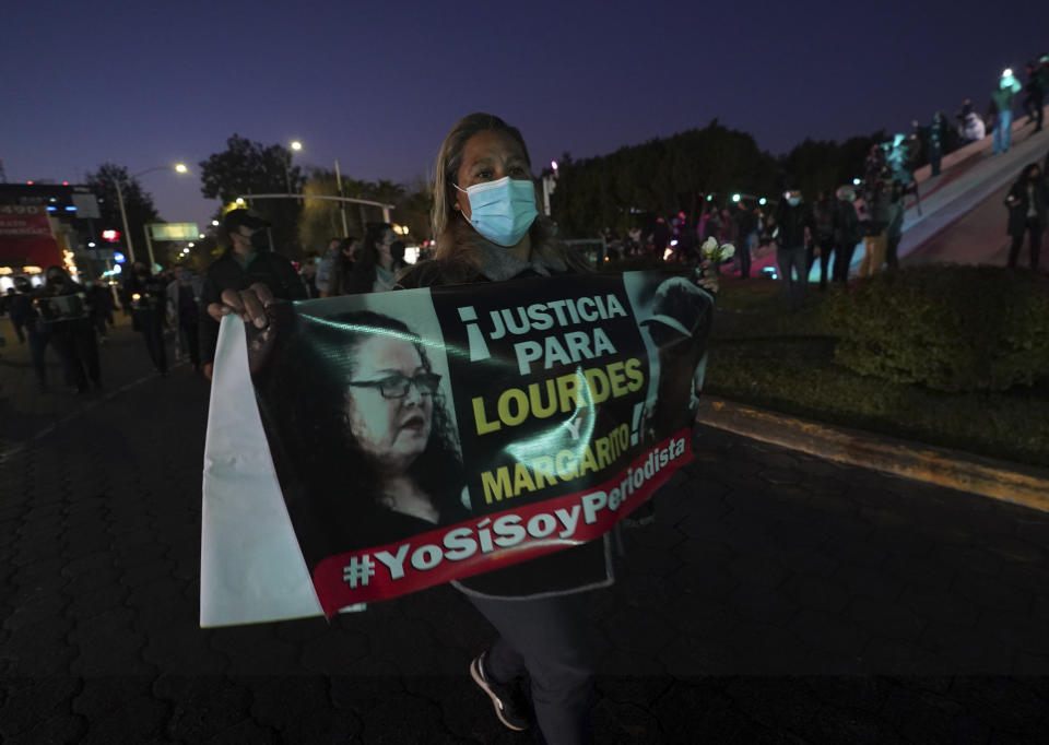 A woman carries a banner that reads in Spanish ¨Justice for Lourdes and Margarito," during a national protest against the murder of journalist Lourdes Maldonado and freelance photojournalist Margarito Martínez, at the Mexico monument in Tijuana, Mexico, Tuesday, Jan. 25, 2022. Mexico's Interior Undersecretary Alejandro Encinas said recently that more than 90% of murders of journalists and rights defenders remain unresolved, despite a government system meant to protect them. (AP Photo/Marco Ugarte)