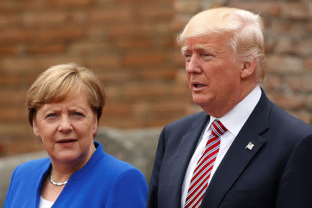 U.S. President Donald Trump and German Chancellor Angela Merkel pose during a family photo at the Greek Theatre during a G7 summit in Taormina, Sicily, Italy, May 26, 2017. REUTERS/Jonathan Ernst