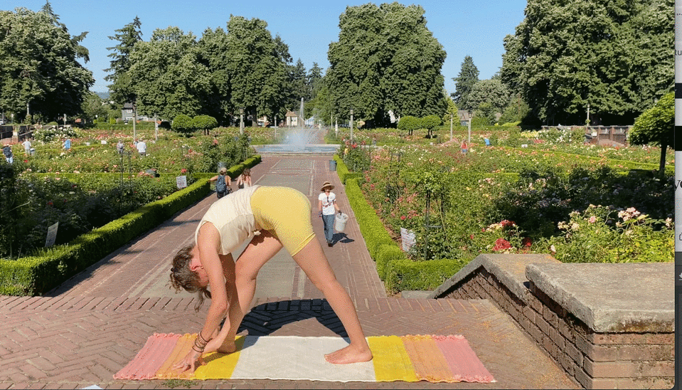 Woman standing on a yoga rug doing Pyramid Pose