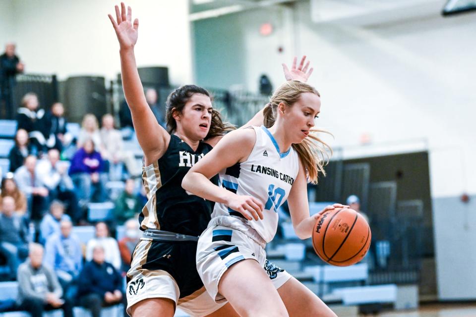 Lansing Catholic's Anna Richards, right, moves the ball as Holt's Allison Metzger defends during the first quarter on Friday, Dec. 2, 2022, at Lansing Catholic High School.