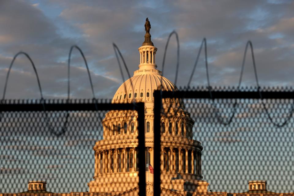 The U.S. Capitol is seen behind a fence with razor wire during sunrise on January 16, 2021 in Washington, DC. 