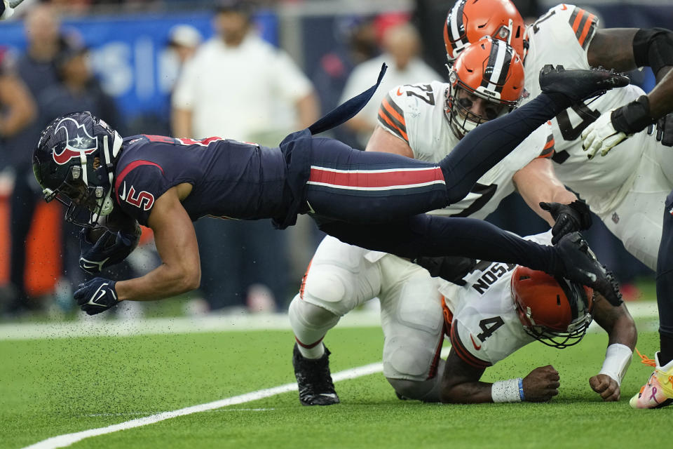 Houston Texans safety Jalen Pitre (5) is upended after intercepting a pass by Cleveland Browns quarterback Deshaun Watson (4) during the first half of an NFL football game between the Cleveland Browns and Houston Texans in Houston, Sunday, Dec. 4, 2022,. (AP Photo/Eric Gay)