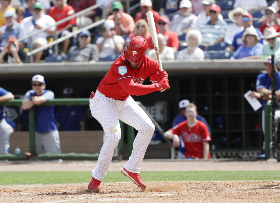 Philadelphia Phillies' Bryce Harper looks down at the baseball after getting hit by a pitch during the sixth inning in a spring training baseball game against the Toronto Blue Jays, Friday, March 15, 2019, in Clearwater, Fla. Harper sustained a bruised right foot Friday, but manager Gabe Kapler said the team wasn't overly worries about the injury. Initial X-rays were negative, the team said, but Harper then left the ballpark for more detailed X-rays. (Yong Kim/The Philadelphia Inquirer via AP)