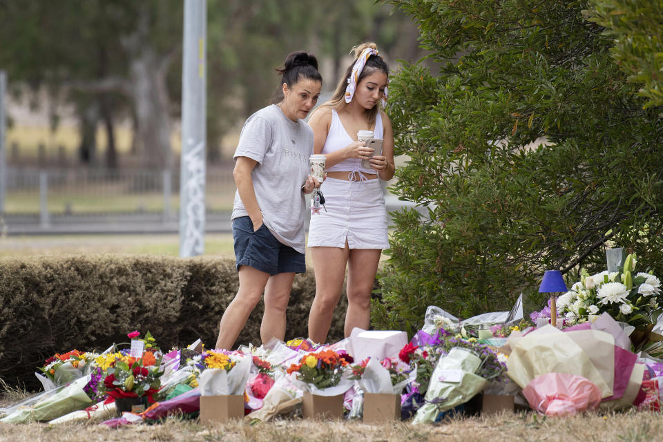 Two women stand at a floral tribute, Friday, Jan. 18, 2019, at the scene where the body of Israeli student Aiia Maasarwe was found earlier in the week in Melbourne, Australia. Maasarwe, a 21-year-old student who had been studying at La Trobe University in Melbourne, was slain at 12:10 a.m. on Wednesday shortly after she got off a tram in the suburb of Bundoora, according to police. (Ellen Smith/AAP Image via AP)