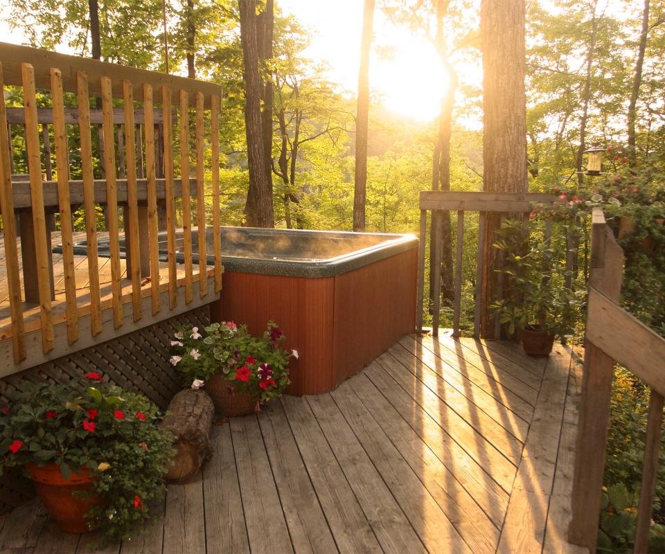 hot tub on decking with woodland view