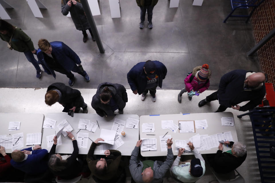 Caucus goers check in at a caucus at Roosevelt High School, Monday, Feb. 3, 2020, in Des Moines, Iowa. (AP Photo/Andrew Harnik)