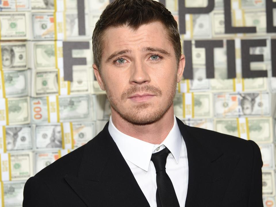 Garrett Hedlund wearing a black suit and tie at a red carpet event in March 2019.