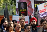 Members of the Confederation of All India Traders hold placards during a protest against the visit of Jeff Bezos to India, in New Delhi