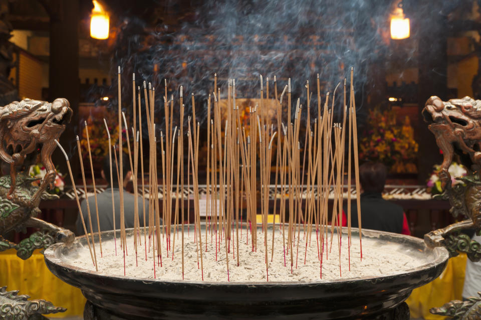 Close up of incense in old Chinese temple interior.