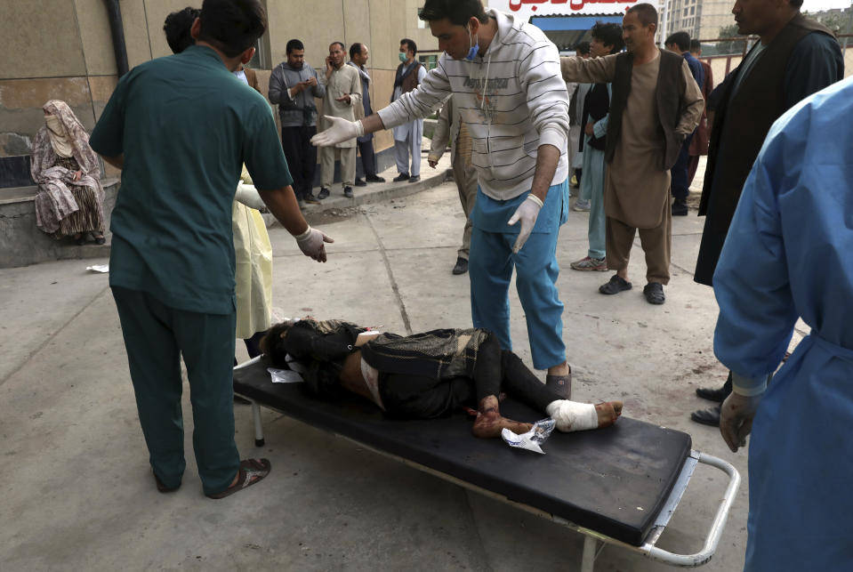 Afghan men try to identify the dead bodies at a hospital after a bomb explosion near a school west of Kabul, Afghanistan, Saturday, May 8, 2021. A bomb exploded near a school in west Kabul on Saturday, killing several people, many them young students, an Afghan government spokesmen said. (AP Photo/Rahmat Gul)